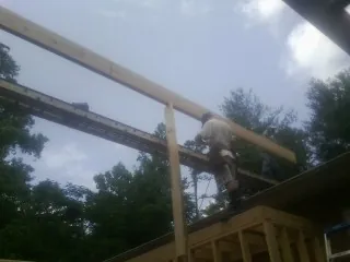 Carpenter setting a ridge beam over a new addition frame — Ice Dam Removal by Roofing Brothers in Dunstable