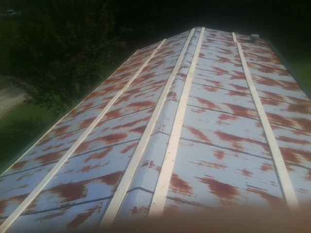 Rusted metal roof panels with new wood purlins before replacement — Storm Damage Roof Repair in Dunstable by Roofing Brothers