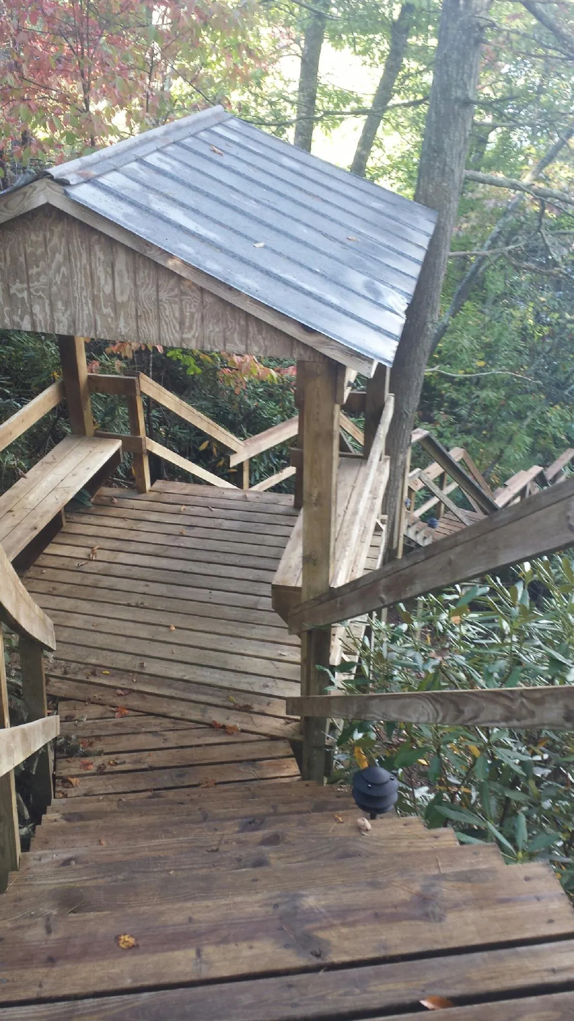 Metal roofed shelter over wooden steps on a wooded walkway — Skylight Repair & Installation work by our crew in Dunstable
