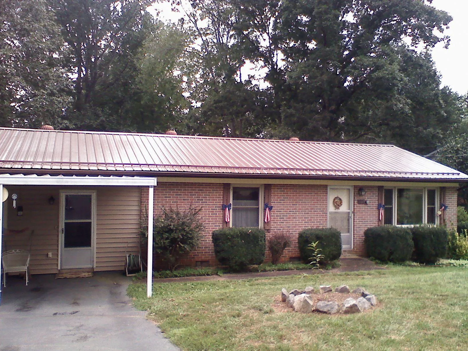 Bronze metal roof and carport on a brick ranch home — Roof Repair work by our crew in Dunstable